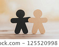 Two cutout figures stand side by side, symbolizing unity and compassion in a tranquil indoor environment. The warm light enhances the sense of connection between the characters, creating an inviting 125520998