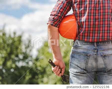 Attractive man in work clothes with a protective helmet 125522136