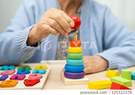 Alzheimer disease AD, Asian elderly woman patient suffering from dementia learn practical motor skills rehabilitation. Alzheimer disease AD, Asian elderly woman patient suffering from dementia learn practical motor skills rehabilitation. 125522378