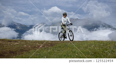 Asian woman riding mountain bike on beautiful mountain top 125522454