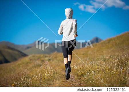 Fitness woman runner running in grassland 125522461