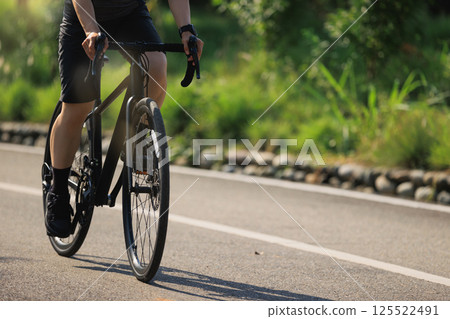 Woman cycling on summer park trail 125522491