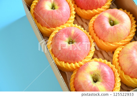 beautiful pink apple in the box on blue background beautiful pink apple in the box on blue background 125522933