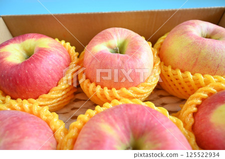 beautiful pink apple in the box on blue background beautiful pink apple in the box on blue background 125522934