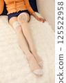Beautiful legs of a woman wearing white garter stockings 125522958