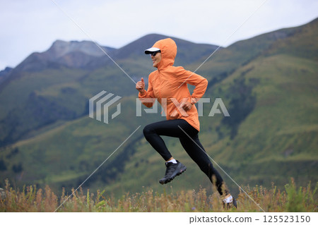 Fitness woman trail runner running on grassland mountain top Fitness woman trail runner running on grassland mountain top 125523150