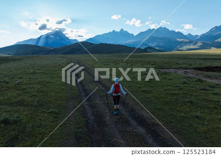 Aerial view of woman trail runner in high altitude mountains Aerial view of woman trail runner in high altitude mountains 125523184