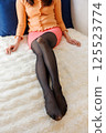 Beautiful legs of a woman wearing black pantyhose and a mini skirt 125523774