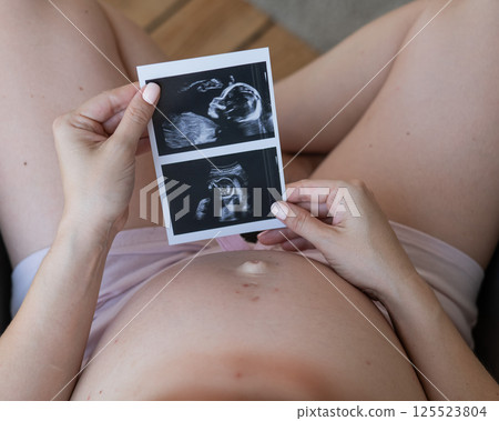 Pregnant woman holding baby ultrasound photo. Pregnant woman holding baby ultrasound photo. 125523804