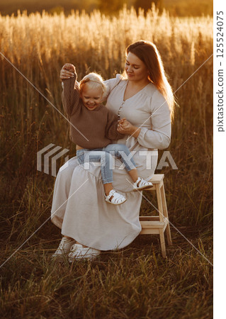 Mother and Daughter Smiling in Wheat Field at Sunset Mother and Daughter Smiling in Wheat Field at Sunset 125524075
