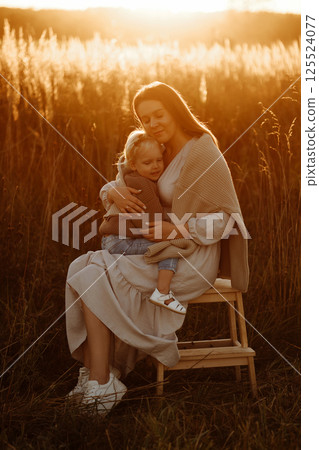 Mother and Daughter Smiling in Wheat Field at Sunset 125524077