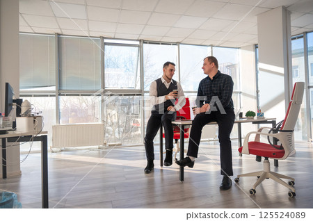 Colleagues drinking coffee in the office.  125524089