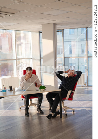 Two Caucasian men solve problems at work. Two Caucasian men solve problems at work. 125524212