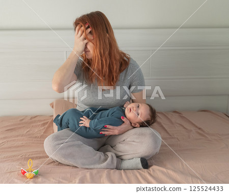 A woman holds a child in her arms and cries. Postpartum depression.  125524433