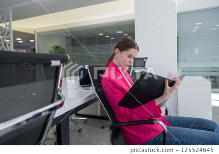Caucasian business woman reading documents in office. Caucasian business woman reading documents in office. 125524645