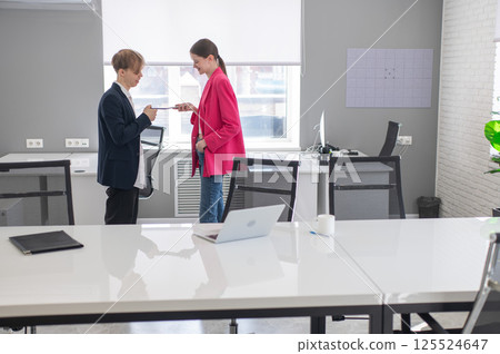 Colleagues use smartphones at work in the office. Colleagues use smartphones at work in the office. 125524647