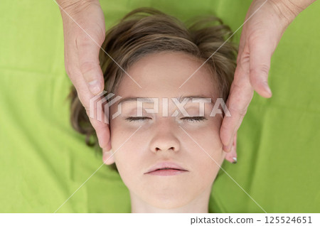 Top view of woman getting facial massage.  125524651