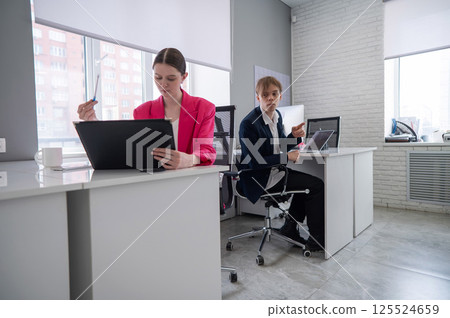 Caucasian young man spying on colleague.  125524659