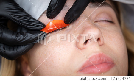The master lays down the roller before the eyelash lamination procedure.  125524725