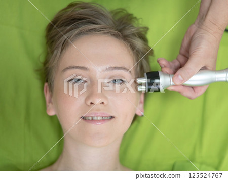 Top view of Caucasian woman undergoing radio wave RF lifting procedure in beauty salon. Top view of Caucasian woman undergoing radio wave RF lifting procedure in beauty salon. 125524767