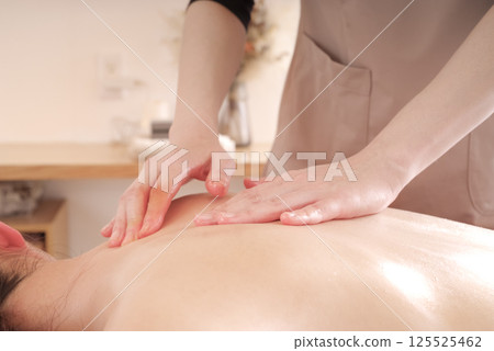 在美容院接受背部按摩的婦女 在美容院接受背部按摩的婦女 125525462