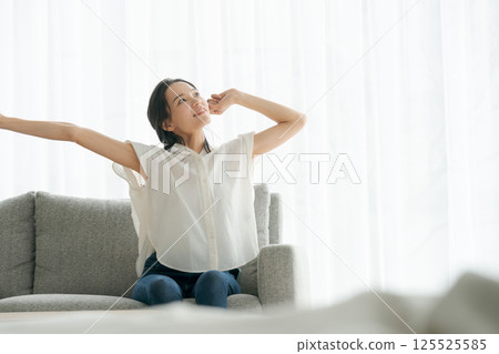 A woman sitting on a sofa and relaxing 125525585