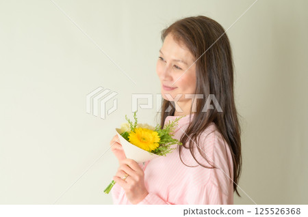 Senior woman holding flowers 125526368