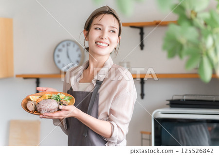 A housewife serving a one-plate lunch in the kitchen 125526842