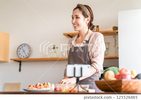 A female cooking class instructor delivering an online cooking class via smartphone 125526865