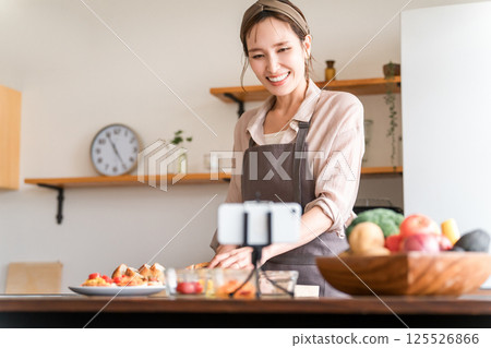 一位女性烹飪課講師在智慧型手機上提供線上烹飪課程 一位女性烹飪課講師在智慧型手機上提供線上烹飪課程 125526866