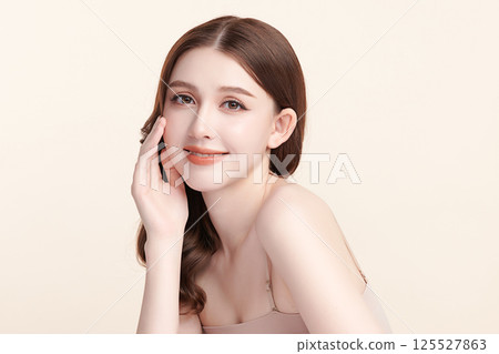 A beautiful young Asian woman with clean, fresh skin against a beige background. Skincare, facial treatment, cosmetology, beauty, and spa. An elegant portrait of an Asian woman. A beautiful young Asian woman with clean, fresh skin against a beige background. Skincare, facial treatment, cosmetology, beauty, and spa. An elegant portrait of an Asian woman. 125527863