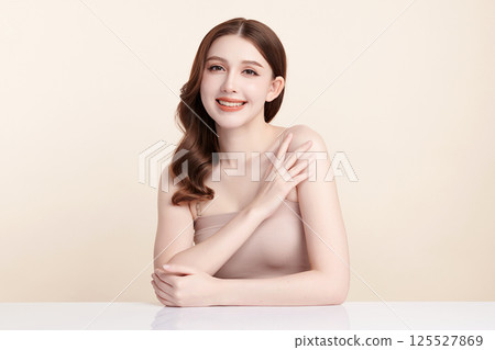 A beautiful young Asian woman with clean, fresh skin against a beige background. Skincare, facial treatment, cosmetology, beauty, and spa. An elegant portrait of an Asian woman. A beautiful young Asian woman with clean, fresh skin against a beige background. Skincare, facial treatment, cosmetology, beauty, and spa. An elegant portrait of an Asian woman. 125527869