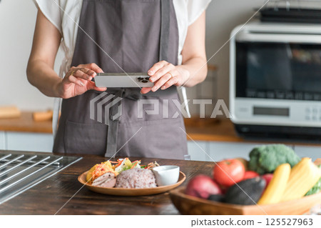 採取有智能手機的婦女一位廚師 採取有智能手機的婦女一位廚師 125527963