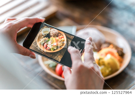 Hands taking pictures of food with a smartphone Hands taking pictures of food with a smartphone 125527964