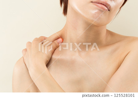 Young Asian woman massaging her shoulders Young Asian woman massaging her shoulders 125528101