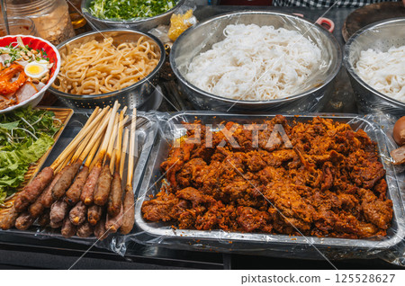 traditional Vietnamese food and meat on counter at Asian night market on street in Da Nang in Vietnam in Asia traditional Vietnamese food and meat on counter at Asian night market on street in Da Nang in Vietnam in Asia 125528627