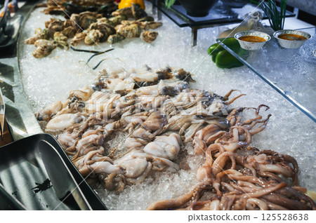 seafood in the Asian buffet at the hotel in restaurant in Asia. Chilled fresh octopus and squid on ice at night market in Vietnam 125528638