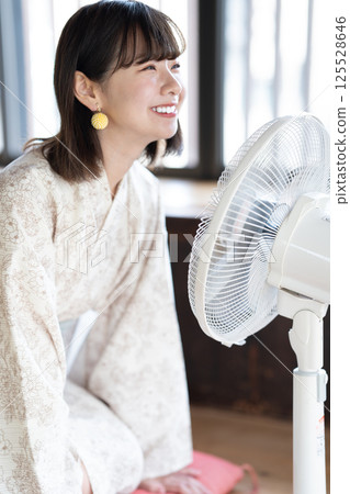 一位身穿浴衣的年輕女子正用扇子納涼 125528646