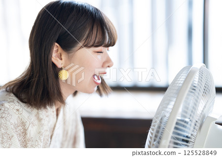 一位身穿浴衣的年輕女子正用扇子納涼 125528849