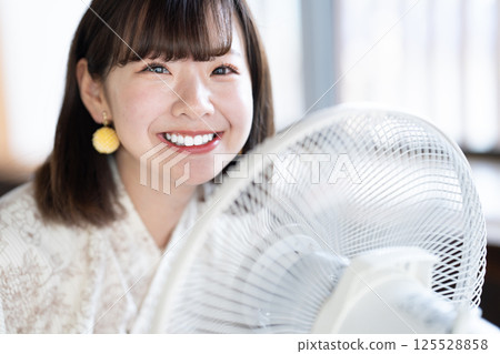 一位身穿浴衣的年輕女子正用扇子納涼 125528858
