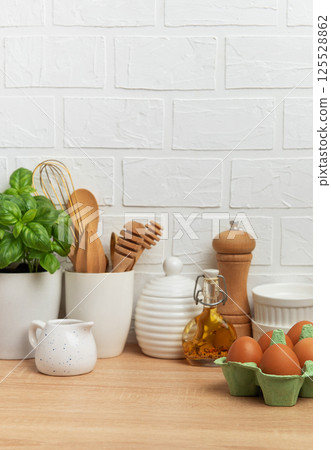 Kitchen utensils, eggs, herbs and spices creating a cozy culinary scene 125528862