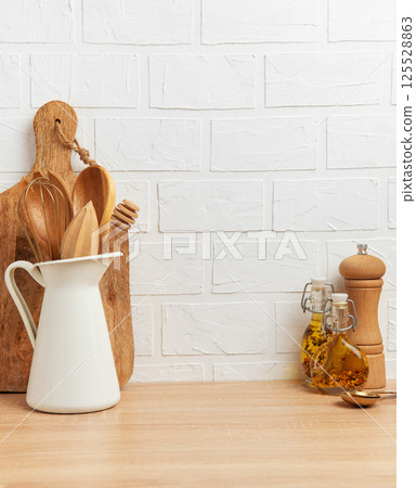 Kitchen utensils resting on wooden countertop by white brick wall Kitchen utensils resting on wooden countertop by white brick wall 125528863