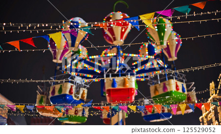 Colorful carousel with lights spinning at night in amusement park 125529052