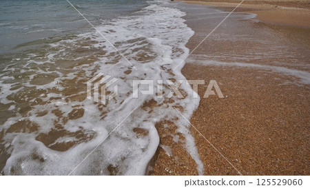 Soft waves caressing sandy crimean coastline, revealing serene maritime landscape Soft waves caressing sandy crimean coastline, revealing serene maritime landscape 125529060