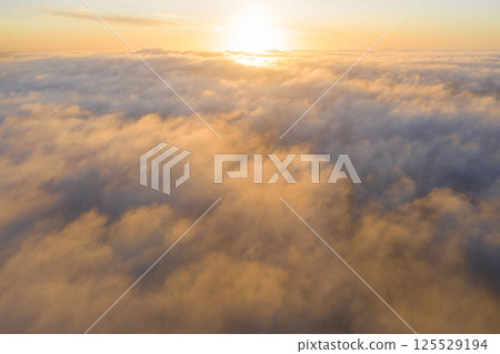 Aerial view gold sunrise over clouds in blue sky. Aerial top view cloudscape. Texture of clouds. View from above. Orange sunrise or sunset over clouds. Panorama clouds texture Aerial view gold sunrise over clouds in blue sky. Aerial top view cloudscape. Texture of clouds. View from above. Orange sunrise or sunset over clouds. Panorama clouds texture 125529194