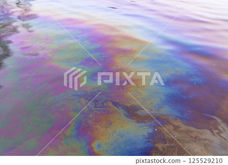 Oil petrol water pollution. Ecological disaster. Slick industry oil fuel spilling water pollution. Water with patches of gasoline and oil. Ecological catastrophy.  Concept of environmental problems 125529210