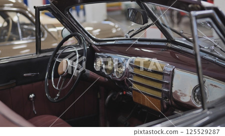 Interior view of vintage convertible car showing steering wheel and dashboard Interior view of vintage convertible car showing steering wheel and dashboard 125529287
