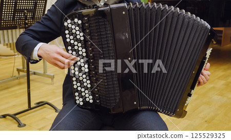 A young guy plays the accordion. Accordion close-up. A young guy plays the accordion. Accordion close-up. 125529325