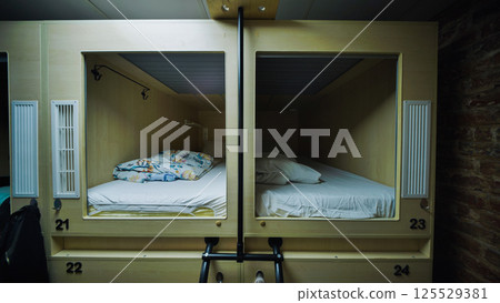 Capsule hotel beds providing comfortable and affordable accommodation 125529381