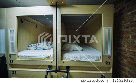 Capsule hotel beds providing comfortable and private sleeping spaces 125529386